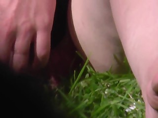 Подглядывание под юбку сидящей на траве девушки и вид ее киски