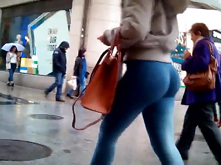 The girl walks the streets in very tight jeans and shines her ass